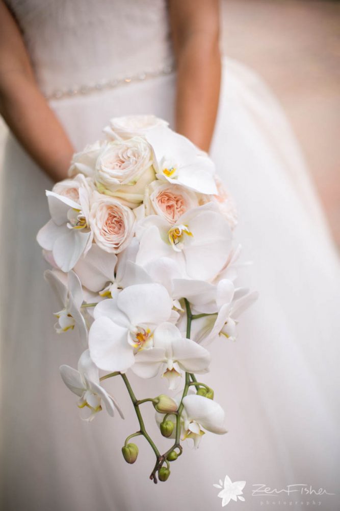 Bride holding bouquet featuring white orchids