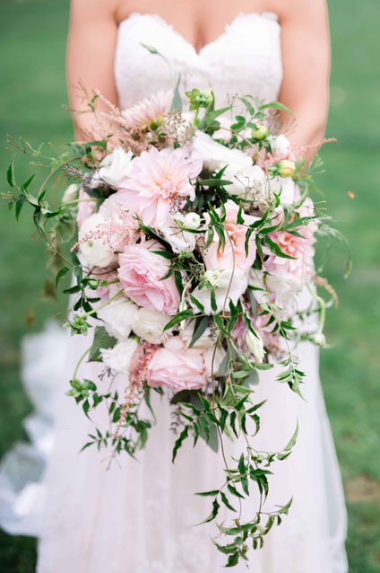 Bride holding a pink and white cascading bridal bouquet.